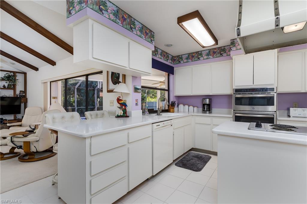 1502 Foxfire Lane Naples, FL 34104 - Photo 26 of 49 a kitchen with stainless steel appliances a stove sink and cabinets