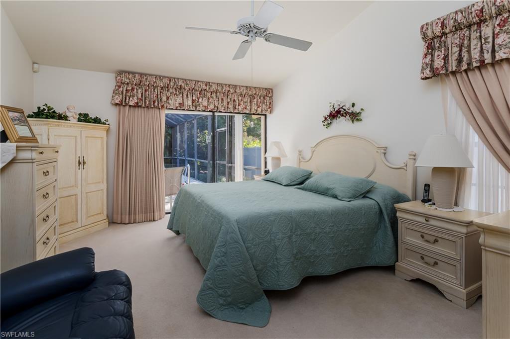 1502 Foxfire Lane Naples, FL 34104 - Photo 27 of 49 a bedroom with a bed and dresser with mirror