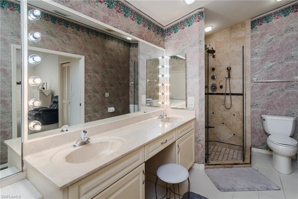 1502 Foxfire Lane Naples, FL 34104 - Photo 30 of 49 a bathroom with a sink toilet a mirror and shower