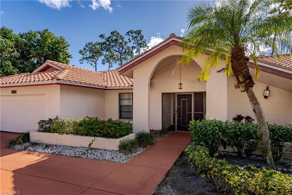 1502 Foxfire Lane Naples, FL 34104 - Photo 3 of 49 a front view of a house with garden
