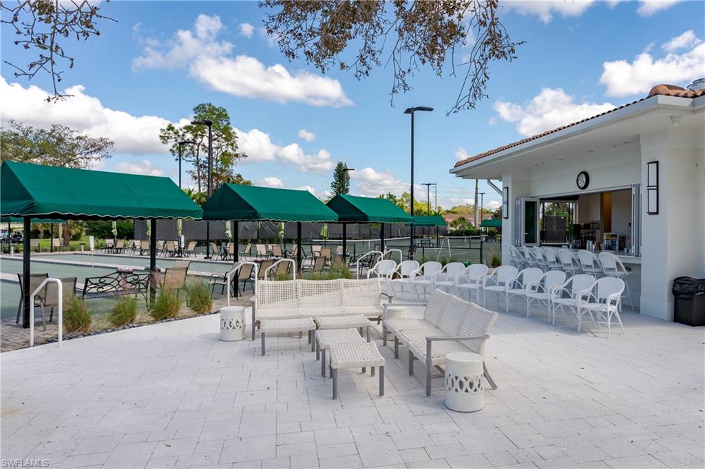 1502 Foxfire Lane Naples, FL 34104 - Photo 40 of 49 a view of a patio with dining table and chairs with a large tree