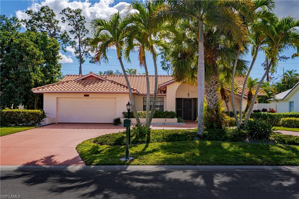 1502 Foxfire Lane Naples, FL 34104 - Photo 4 of 49 a front view of a house with a yard and garage