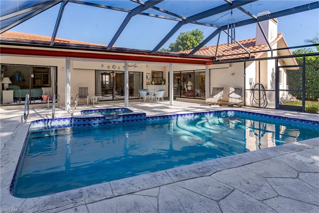 1502 Foxfire Lane Naples, FL 34104 - Photo 6 of 49 front view of a house with swimming pool table and chairs