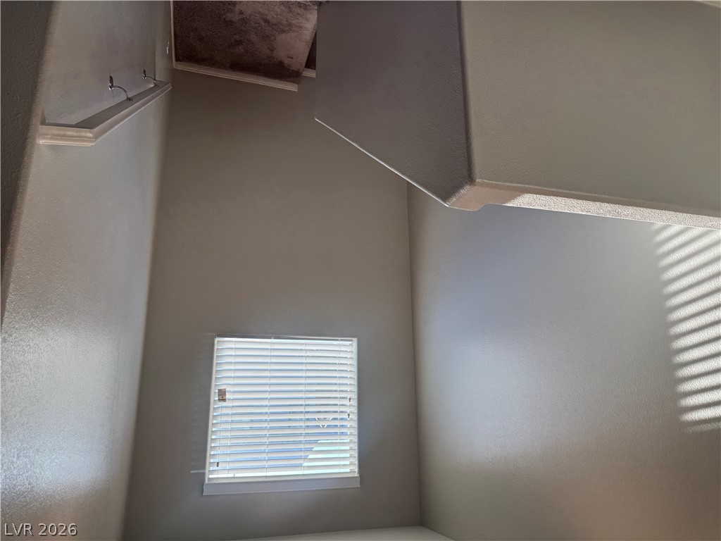 55 Canopus Ridge Way Las Vegas, NV 89183 - Photo 23 of 53 A high-ceilinged stairway area is illuminated by natural light filtered through a classic window.