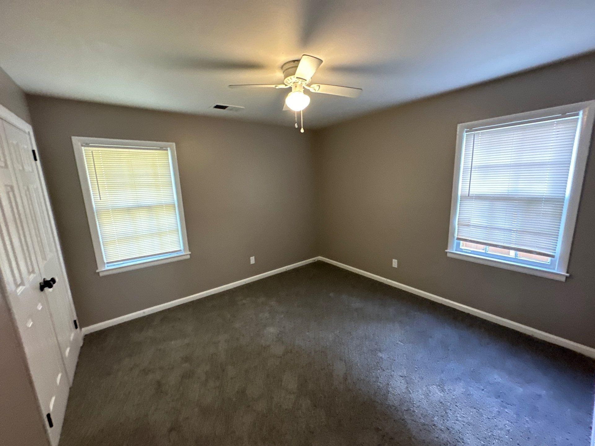 10 West Mitchell Road Memphis, TN 38109 - Photo 5 of 11 Unfurnished bedroom with dark colored carpet, a closet, baseboards, visible vents, and ceiling fan