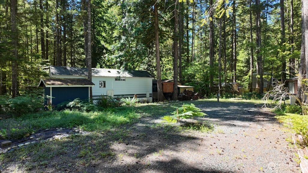 82 Riverside Drive Deming, WA 98244 - Photo 4 of 33 a backyard of a house with a garden and plants