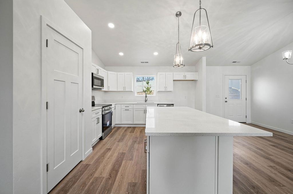 166 Orchard View Way Grand Junction, CO 81503 - Photo 6 of 20 a kitchen with kitchen island a sink stainless steel appliances and white cabinets
