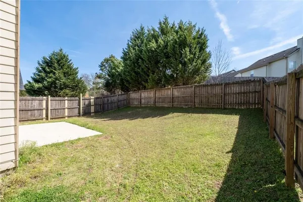 a view of a house with backyard and a tree