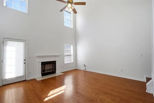an empty room with windows a fireplace
