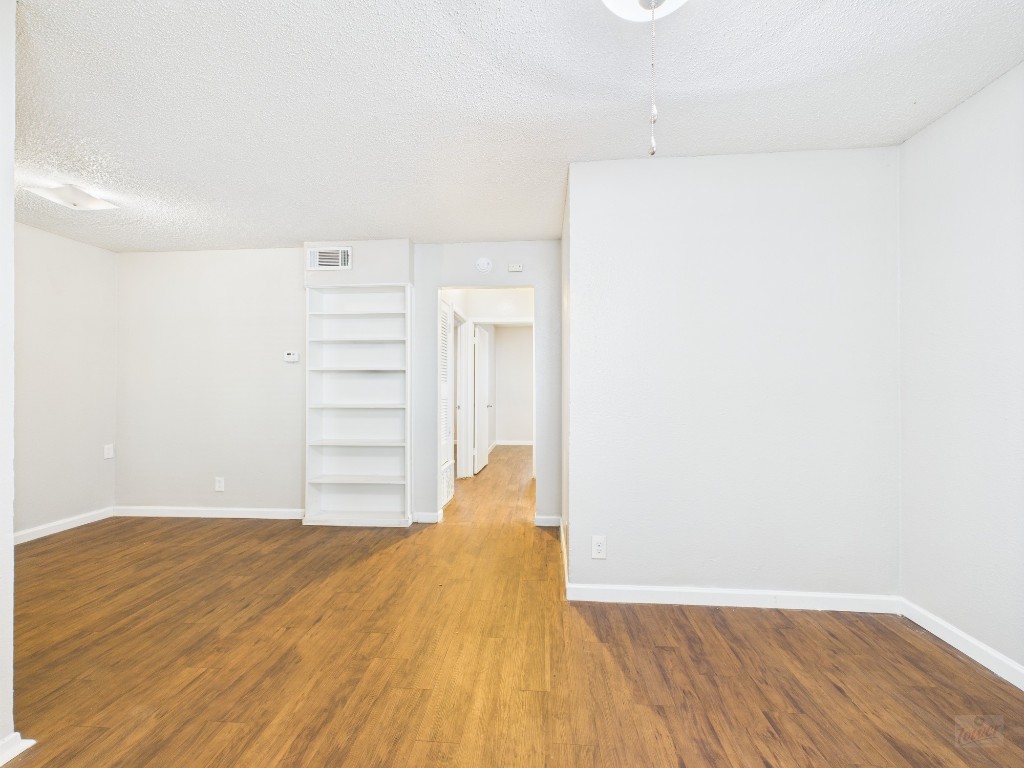 a view of a room with wooden floor