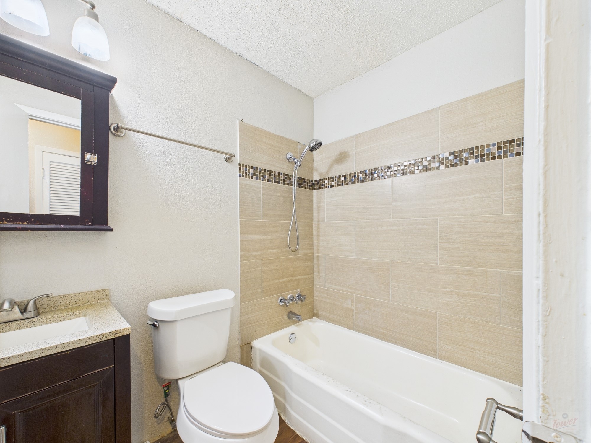 2401 Manor Road, Unit 136 Austin, TX 78722 - Photo 6 of 12 a bathroom with a toilet a sink and bathtub