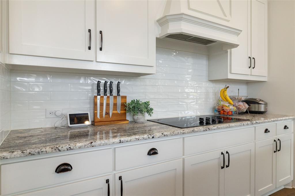 4045 Grove Valley Road Midlothian, TX 76065 - Photo 14 of 34 Kitchen with light stone counters, white cabinetry, black electric cooktop, and decorative backsplash