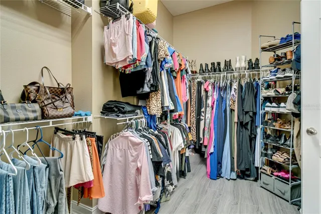 a view of walk in closet with clothes and shoes