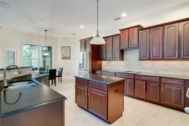 a kitchen with stainless steel appliances granite countertop a sink a stove and a refrigerator
