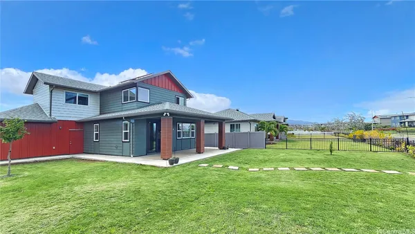 a view of a house with a big yard and large tree
