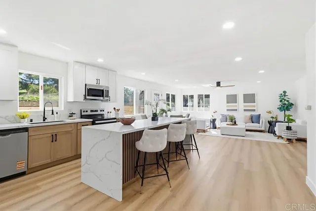 a living room with furniture a dining table wooden floor and a sink