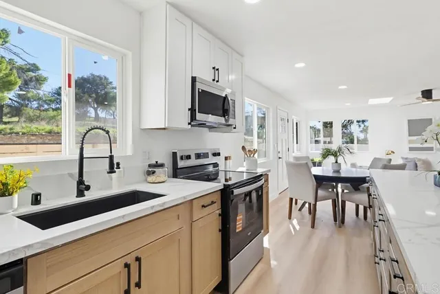 a kitchen with stainless steel appliances granite countertop a sink a stove and cabinets