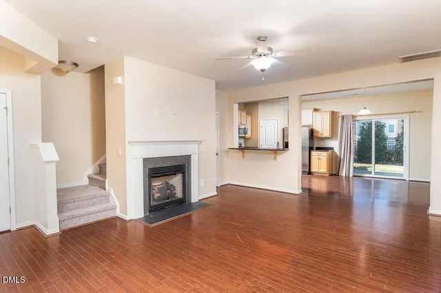 a view of a livingroom with wooden floor and a fireplace