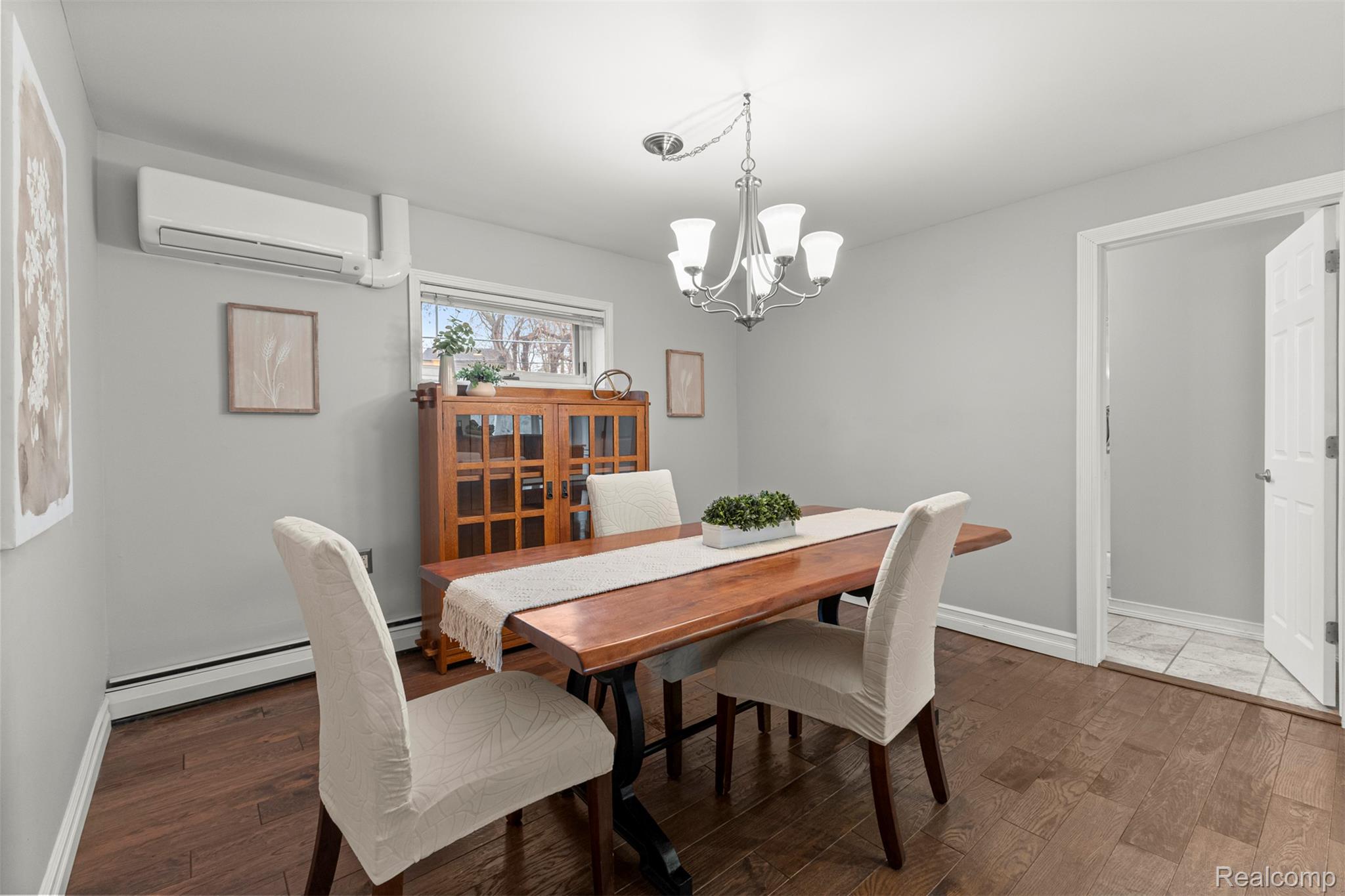 45401 West 9 Mile Road Novi, MI 48374 - Photo 9 of 67 Dining room with a chandelier, an AC wall unit, baseboard heating, and dark wood-style flooring