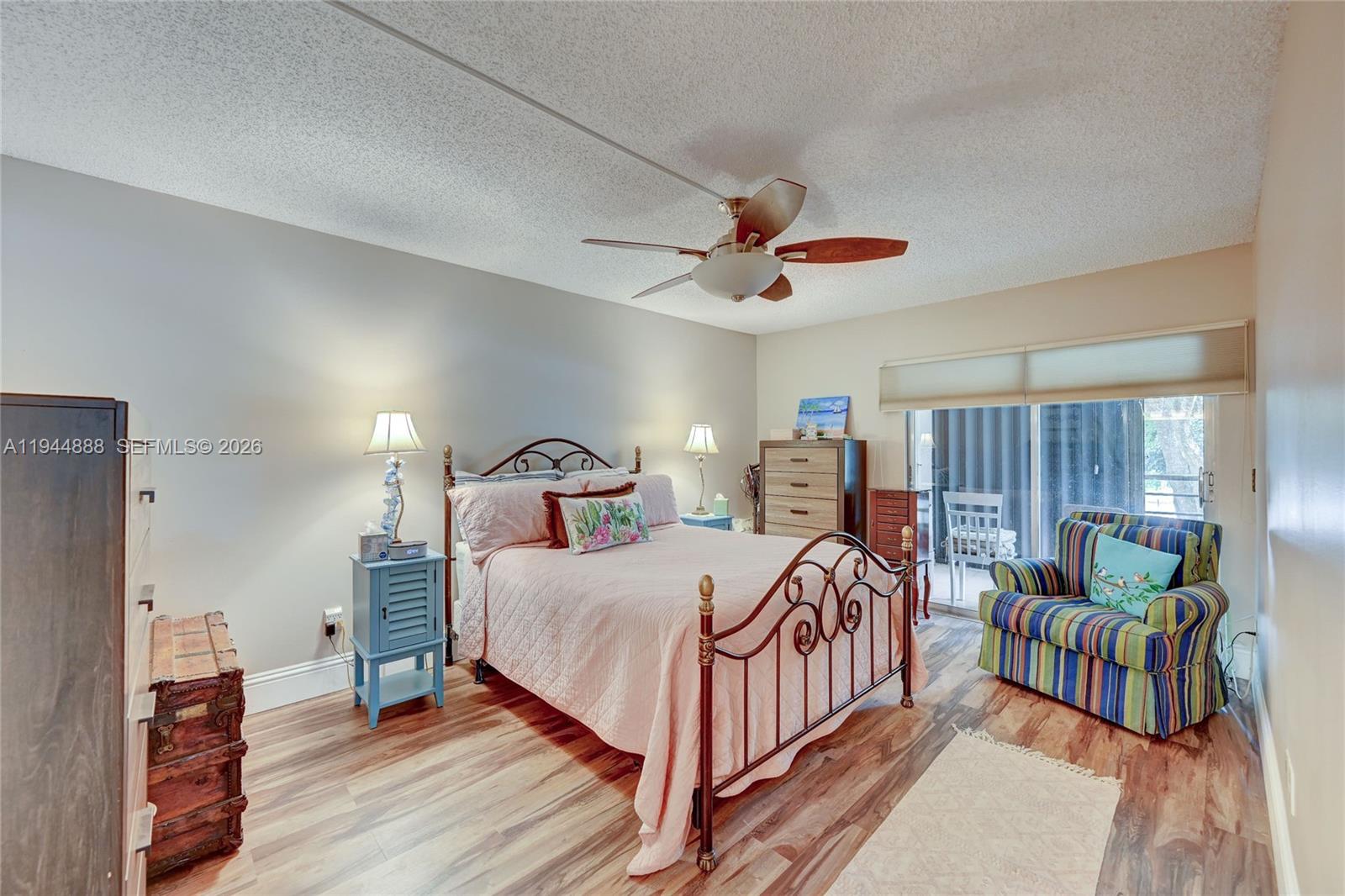 23344 Carolwood Lane, Unit 303 Boca Raton, FL 33428 - Photo 12 of 26 a bedroom with a bed and a chandelier