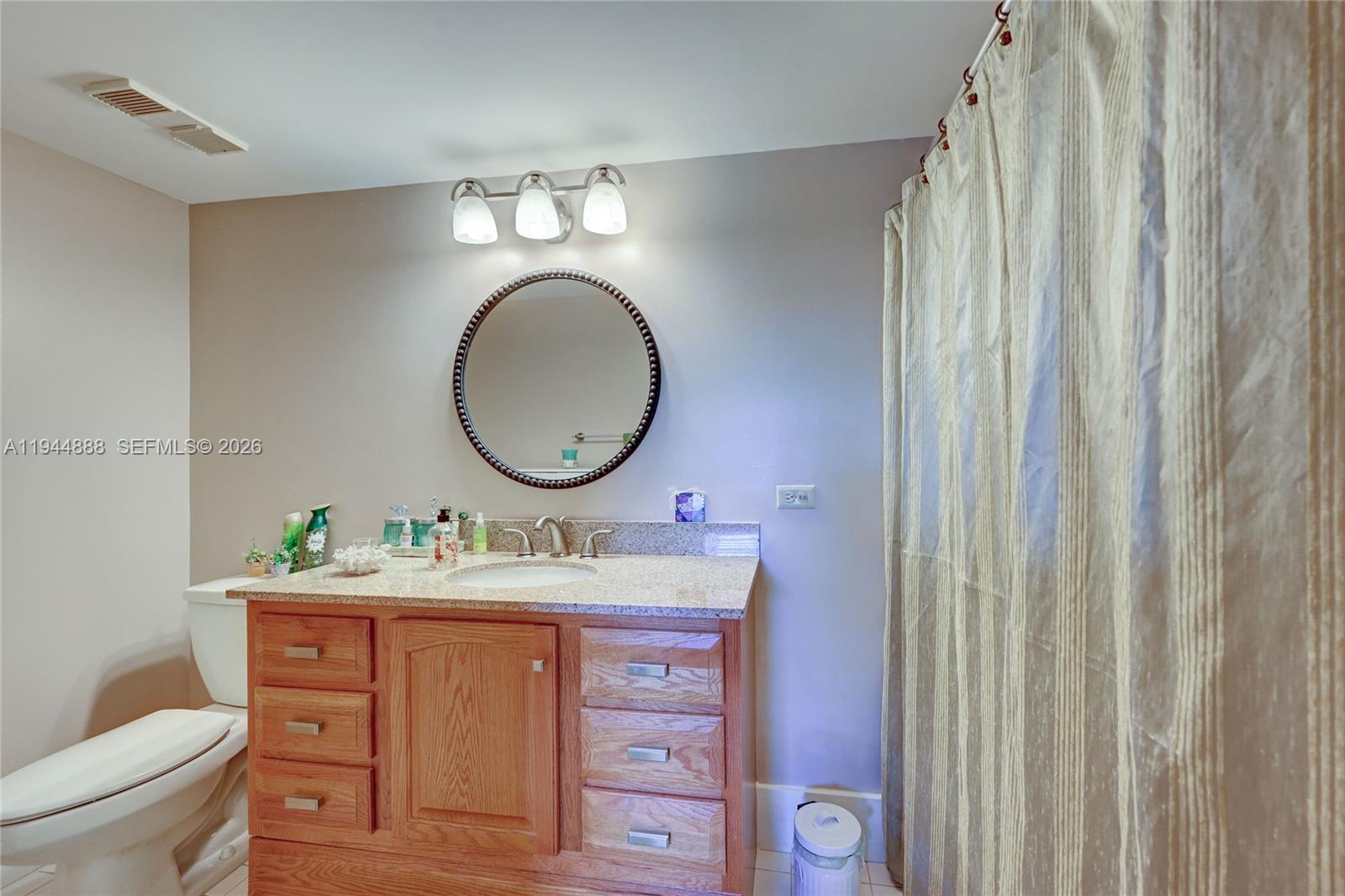 23344 Carolwood Lane, Unit 303 Boca Raton, FL 33428 - Photo 21 of 26 a bathroom with a toilet sink and mirror