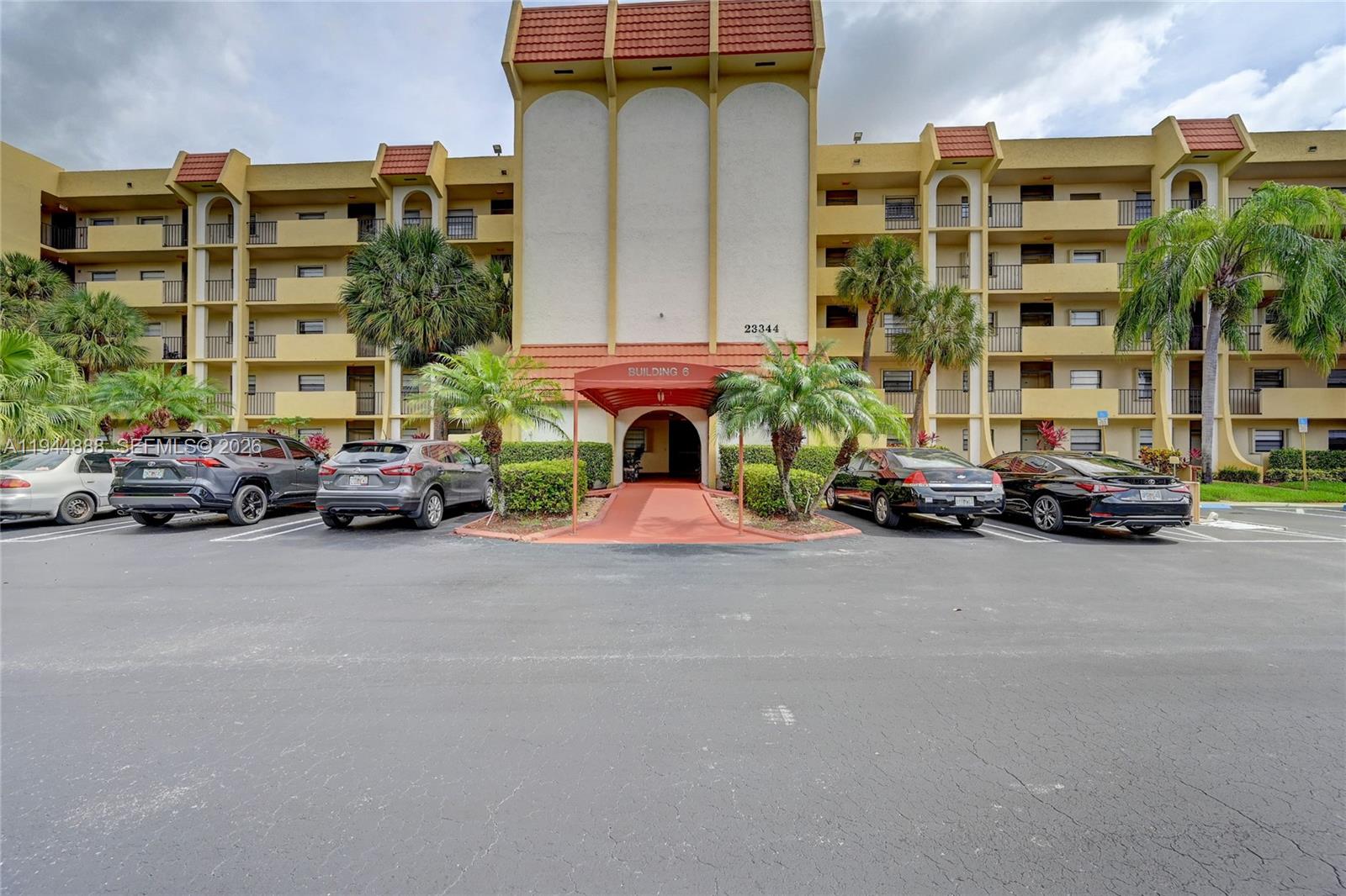 23344 Carolwood Lane, Unit 303 Boca Raton, FL 33428 - Photo 23 of 26 a car parked in front of a building