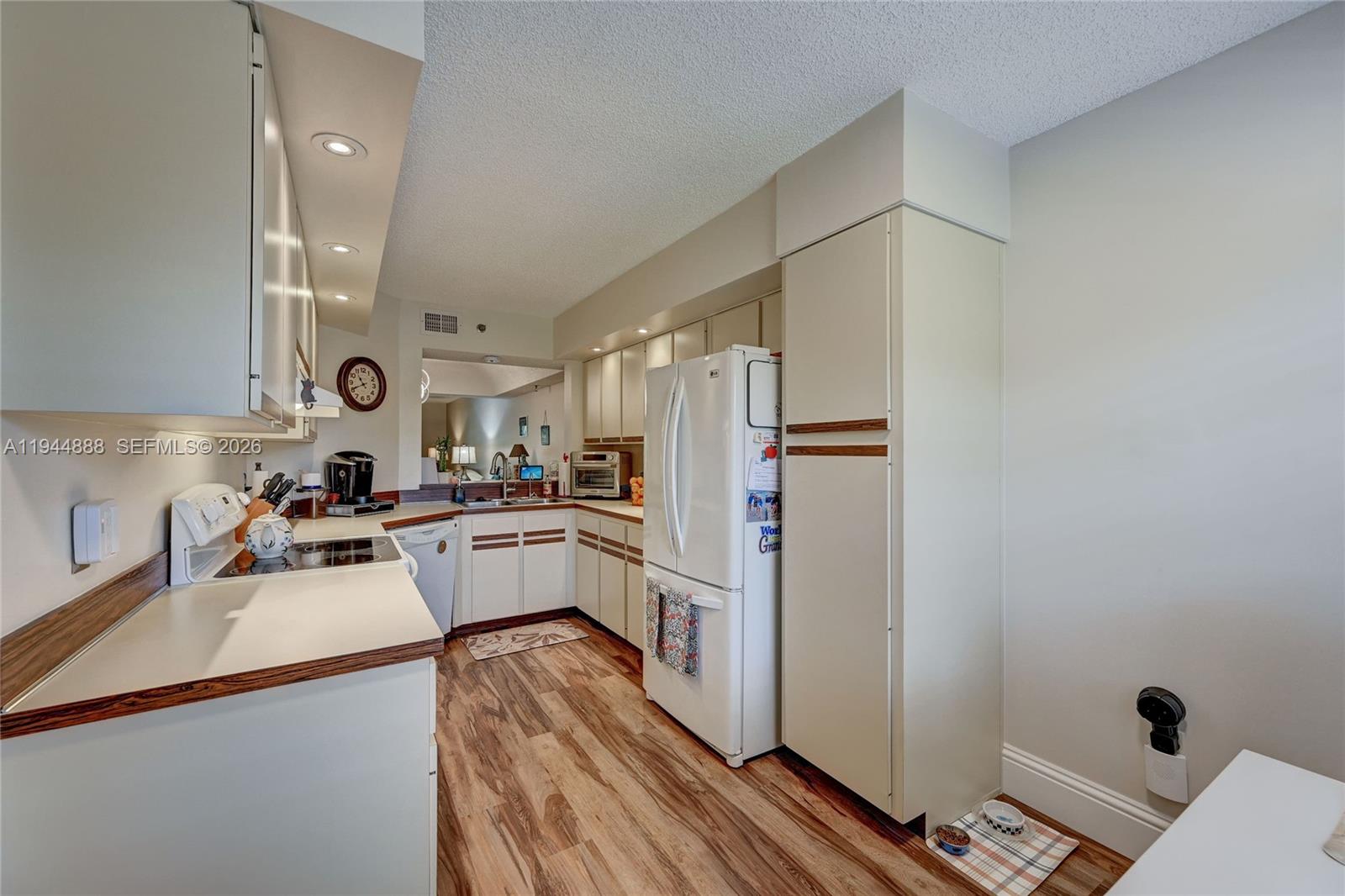 23344 Carolwood Lane, Unit 303 Boca Raton, FL 33428 - Photo 9 of 26 a kitchen with a refrigerator and a sink