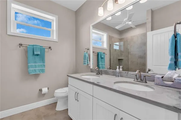 a bathroom with a granite countertop sink mirror and toilet