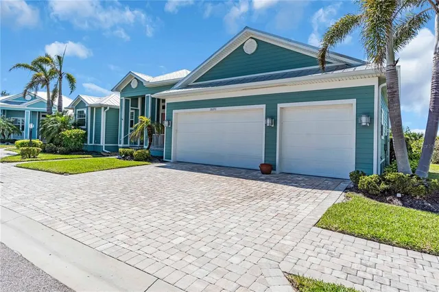 a front view of a house with a yard and potted plants