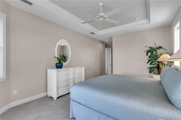 a bedroom with a bed chandelier dresser and a window
