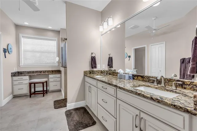 a spacious bathroom with double vanity a granite counter tops and a mirror