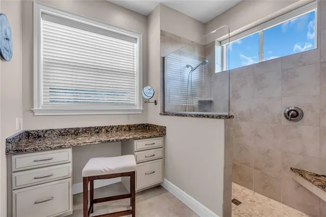 a kitchen with granite countertop white cabinets and a stove