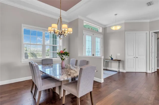 a dining room with furniture potted plants and wooden floor