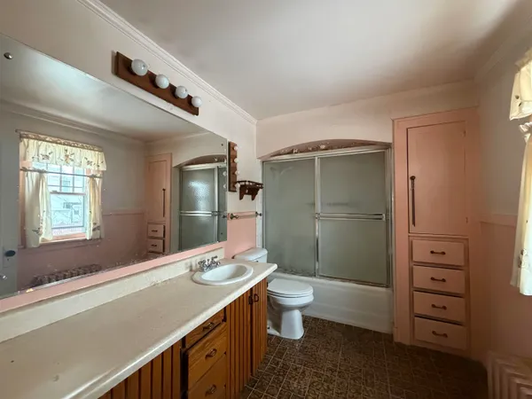 a bathroom with a double vanity sink a toilet and shower