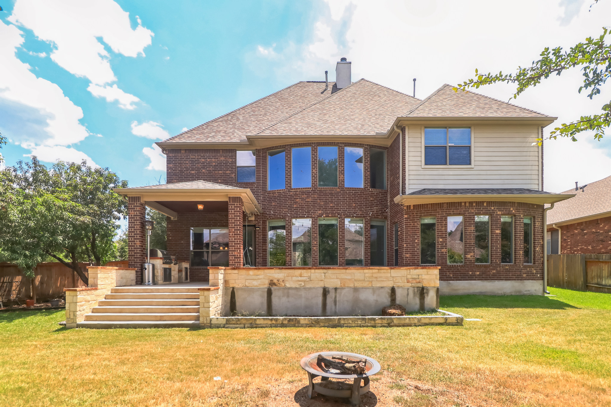3913 Remington Road Cedar Park, TX 78613 - Photo 30 of 32 An inviting stone patio and grassy yard frame the classic brick and siding exterior.