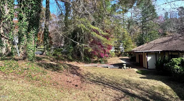 a view of a backyard with a table and chairs under an umbrella