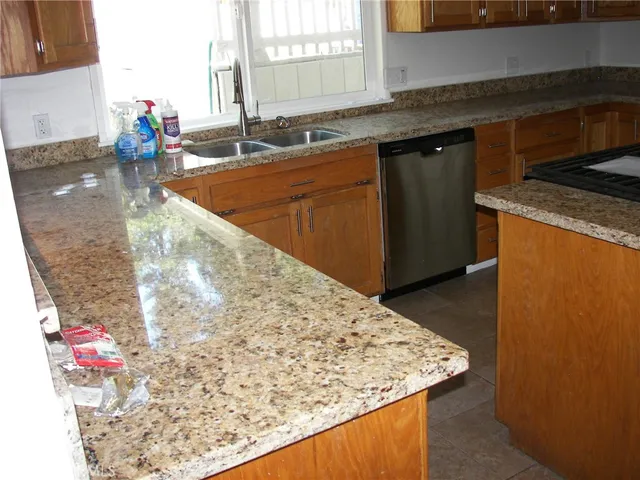 a kitchen with granite countertop sink and cabinets