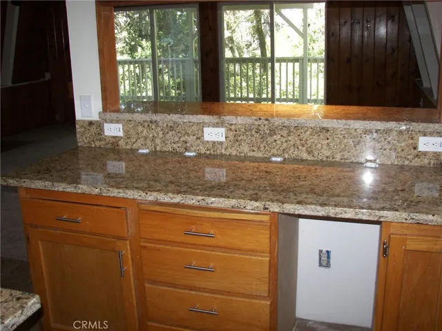 a view of a kitchen with granite countertop cabinets