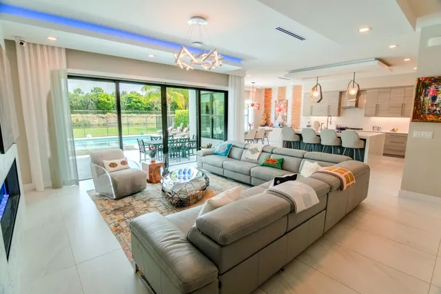 a kitchen with stainless steel appliances kitchen island granite countertop a table chairs sink and cabinets