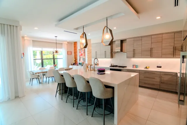 a kitchen with stainless steel appliances a table chairs and a refrigerator