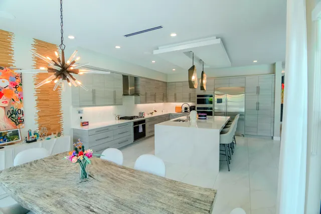 a kitchen with a stove a sink a dining table and chairs