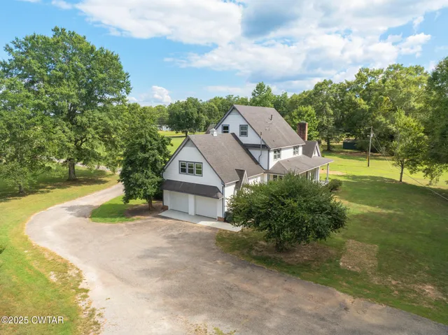 a view of a house with a yard and potted plants