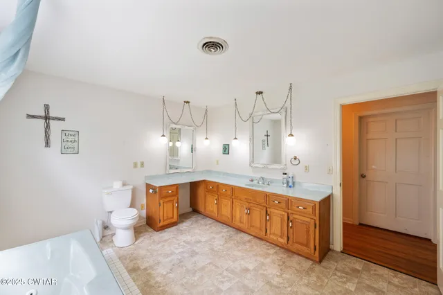 a living room with a table chairs and a kitchen view