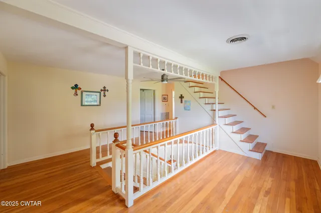 a dining room with wooden floor a chandelier a wooden table and chairs
