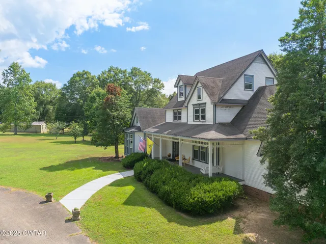 a view of house with a yard and sitting area