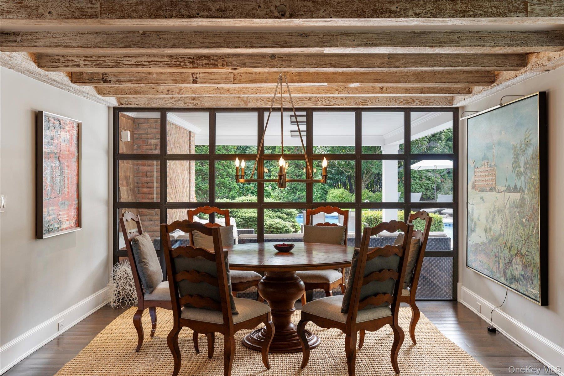 231 Flying Point Road Southampton, NY 11968 - Photo 7 of 34 Dining area featuring dark wood-style flooring, beam ceiling, a chandelier, and a wall of windows
