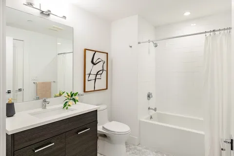 a bathroom with a sink a toilet and shower
