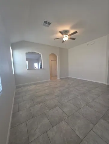 en empty room with windows and fan