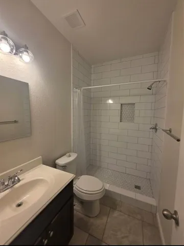 a bathroom with a sink a toilet and shower