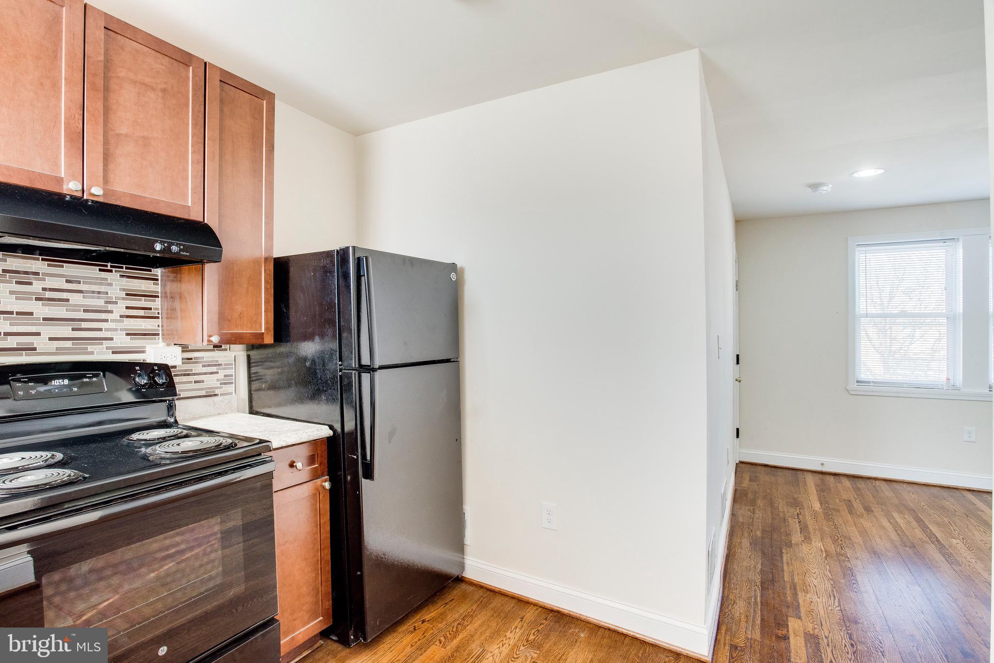 149 Denison Street, Unit 2 Baltimore, MD 21229 - Photo 11 of 19 a kitchen with a refrigerator stove and cabinets